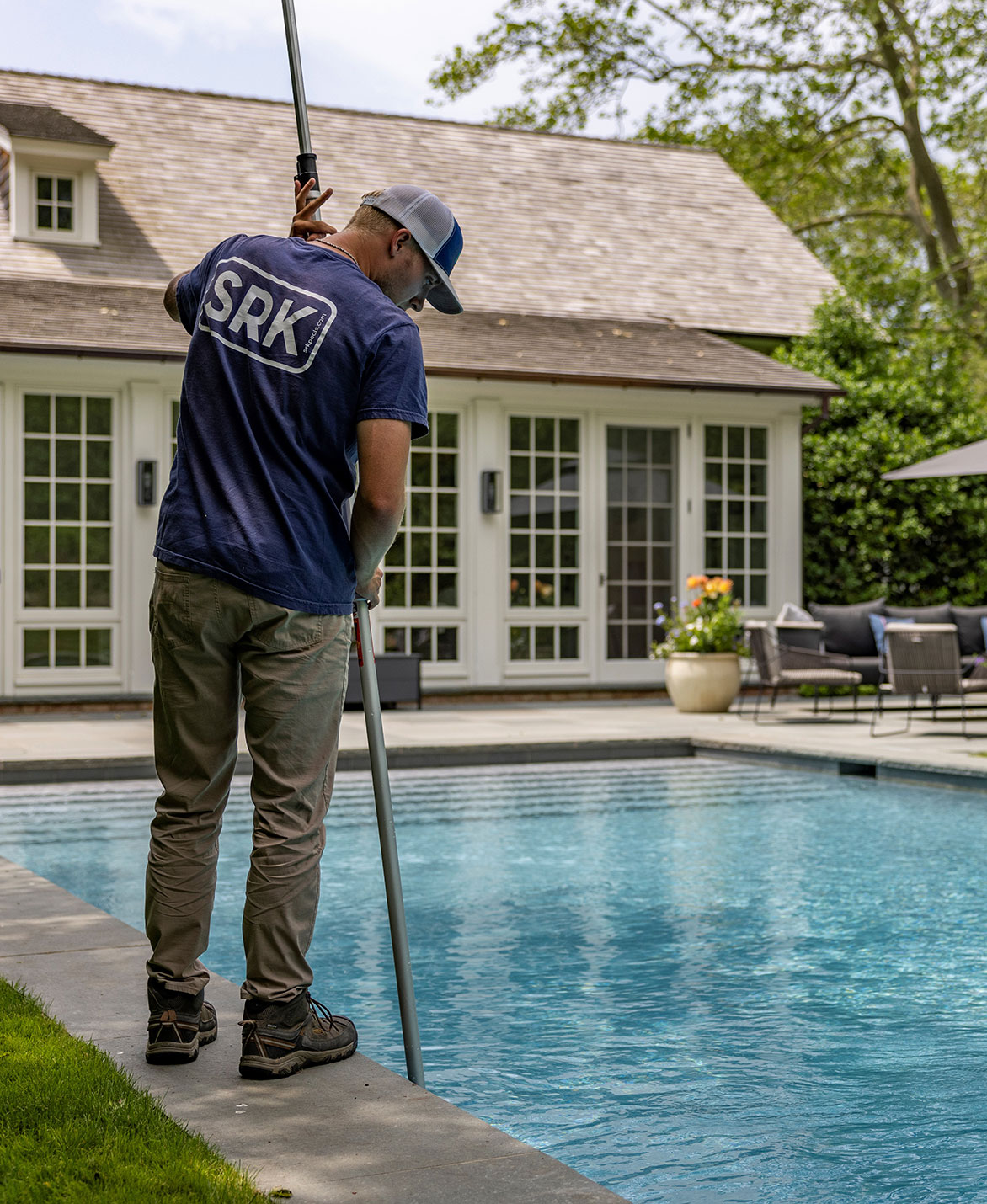 Pool technician working to clean a pool.